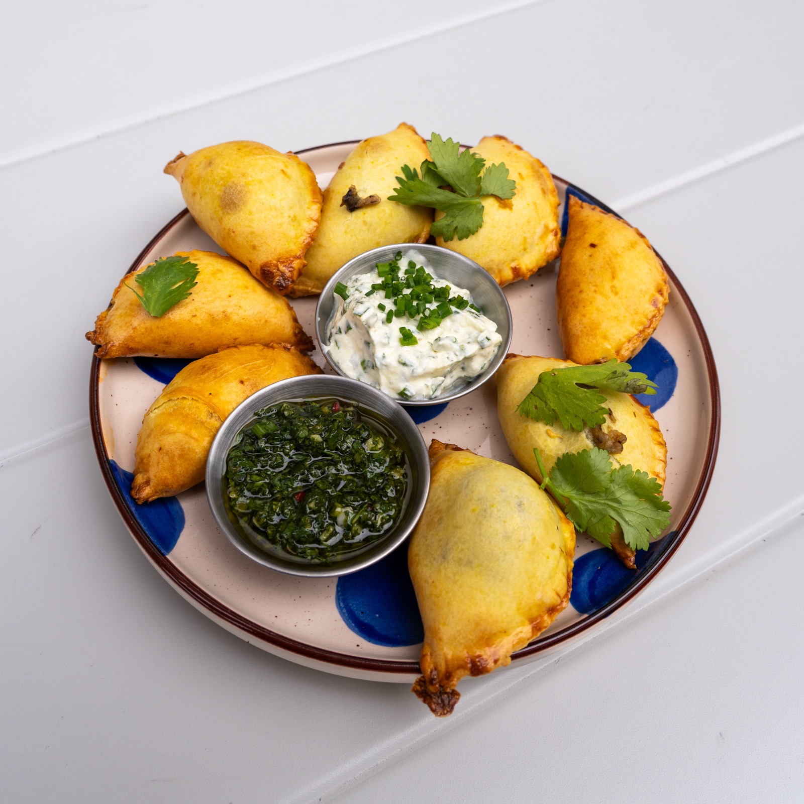 Plate of vegetarian empanadas with chimichurri and suero costeño at String Taste in Kraków